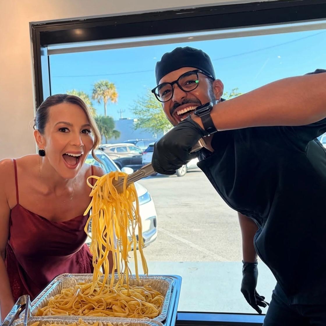 Chef serving fresh pasta to a happy guest